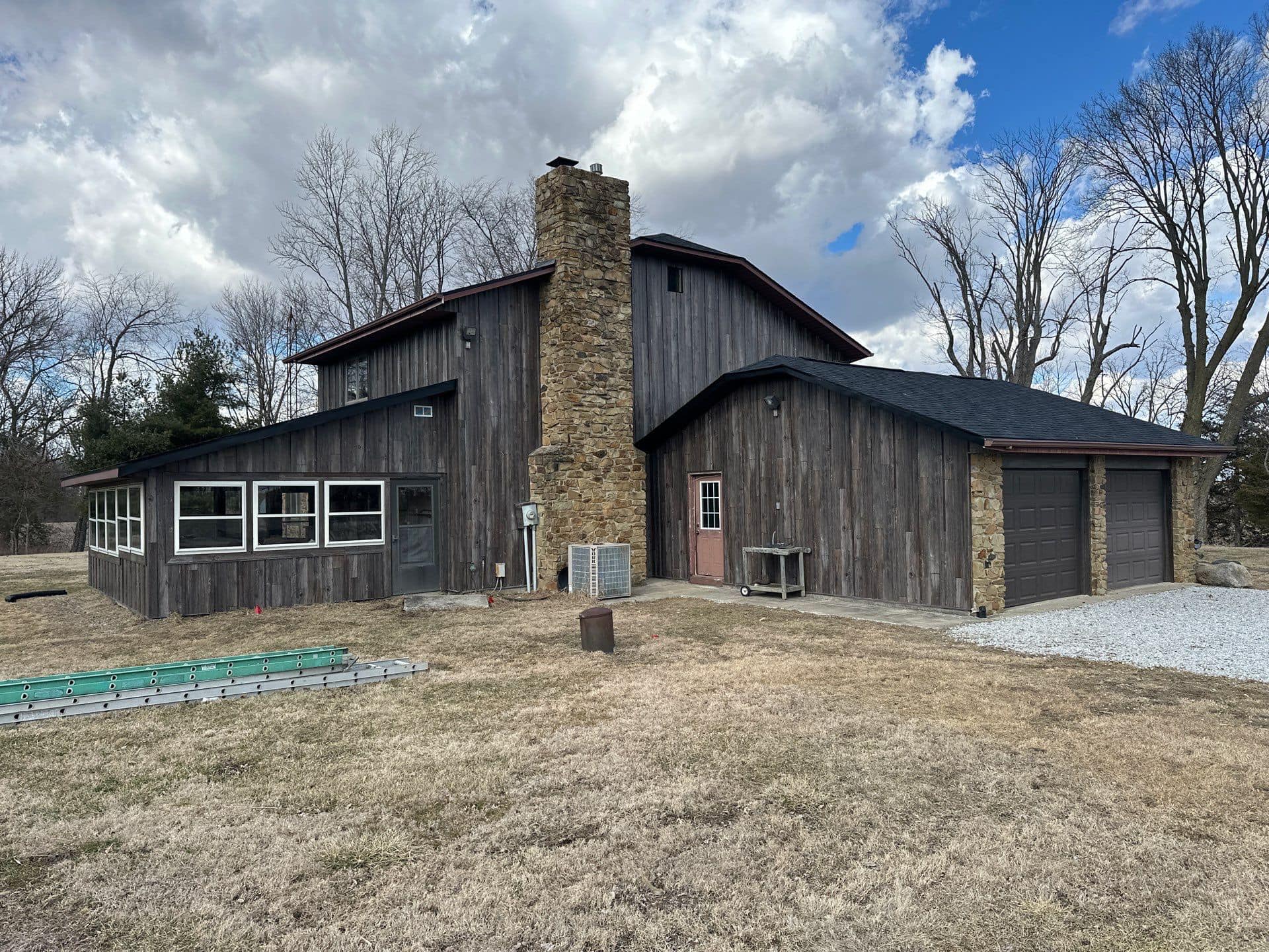 MPbatten steel siding barnwood Residential building with black MPBatten steel board and batten siding in wood-metal